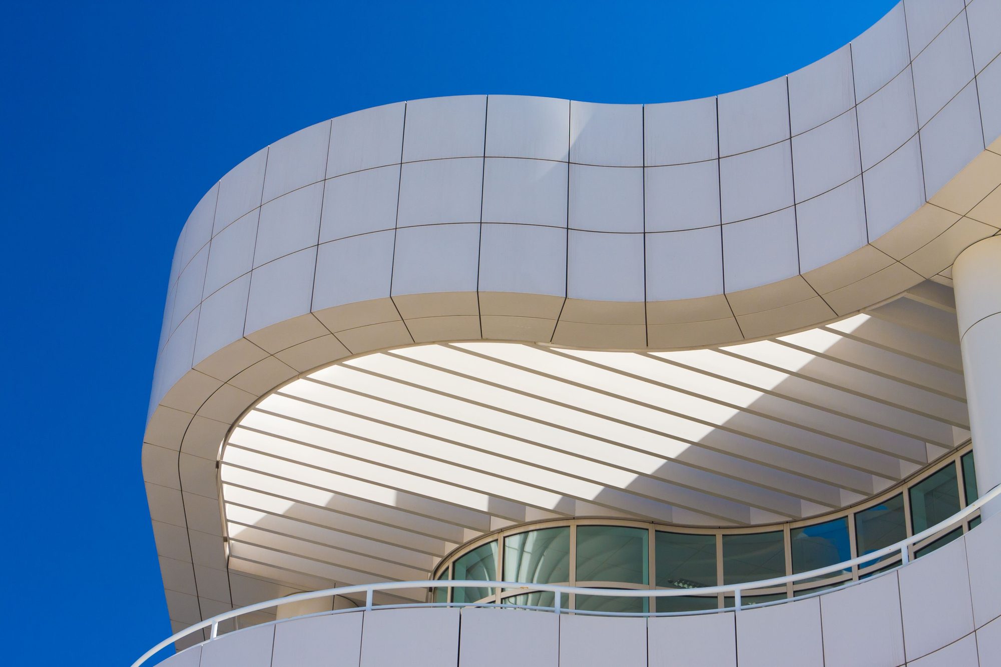 White architecture curving in layered balconies against a blue sky